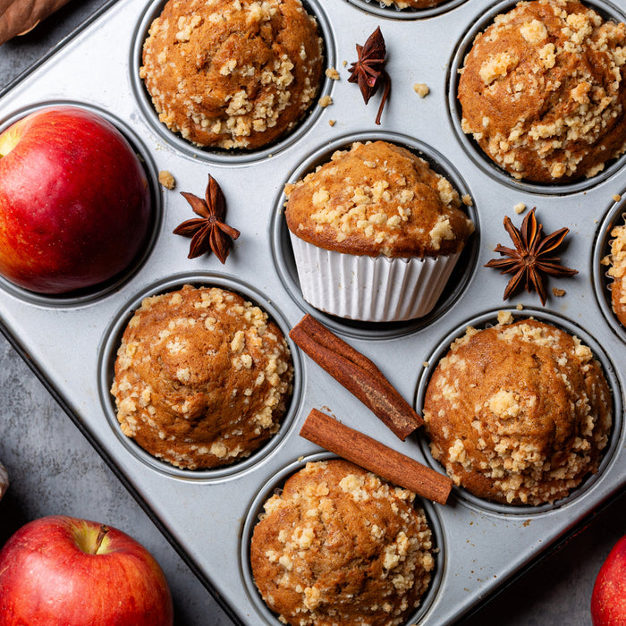 Apple Oatmeal Muffins in a muffin pan surrounded by fall elements