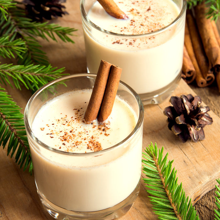 Eggnog in a glass on a table with holiday decorations