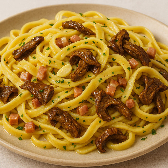 porcini fettucine on a white plate on a white countertop