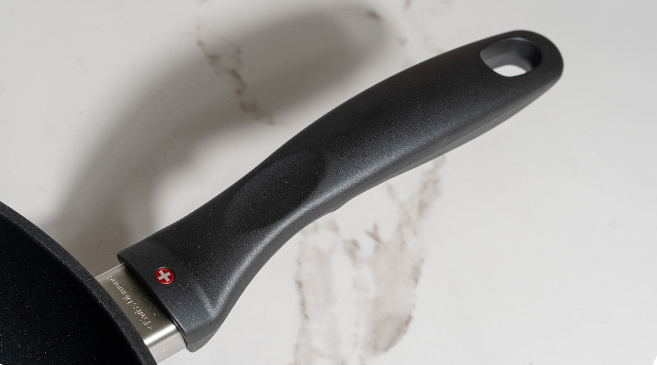 black handle attached to a fry pan on a marble kitchen counter