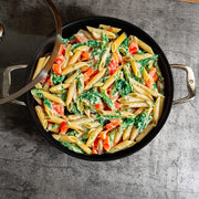 Nonstick Clad 5.3 qt Stainless Chef's Pan with Glass Lid - Induction in use with food on kitchen counter