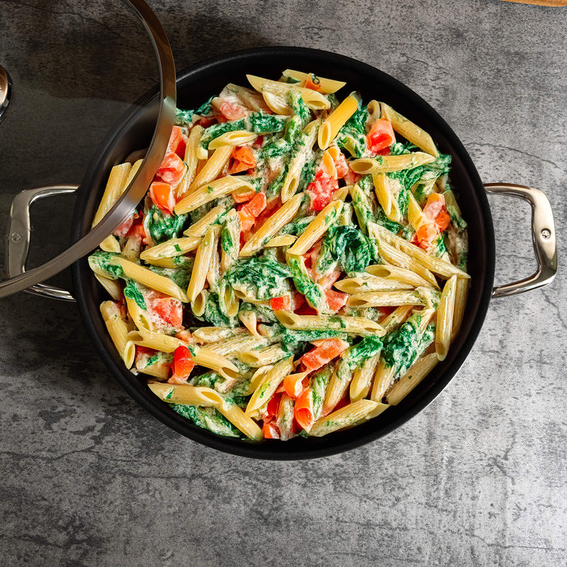 Nonstick Clad 5.3 qt Stainless Chef's Pan with Glass Lid - Induction in use with food on kitchen counter